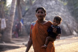 Fisher woman carrying her child at hip