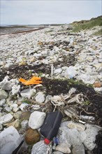 Plastic rubbish along high-water mark on deserted beach