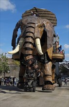 Tourists riding on gigantic mechanical elephant
