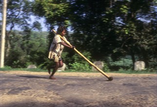 Tribal boy playing improvised pulley