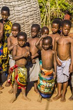 Children watch with interest at traditional customs in real African village
