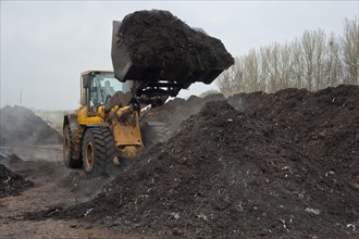 Volvo loader turns green compost waste for aeration at municipal landfill near Chester