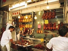 Man prepares meat and poultry in cafe