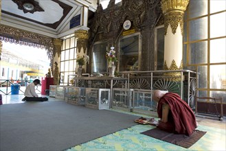 Monk with tattoo praying in temple