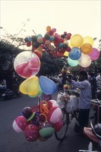 A traditional balloon vendor selling balloons in front of VOC Park
