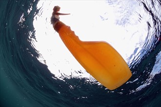 Plastic spray bottle floating in sea