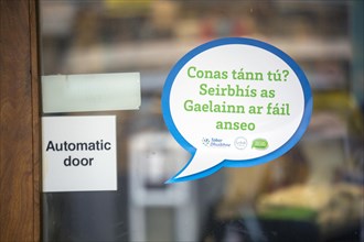 A sign in the West Kerry Gaeltacht advertising services through the medium of the Irish language. The sign reads 'How are you? Services in Irish available here'