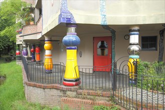 Corridor with colourful supporting poles and columns at the Hundertwasser House in Bad Soden im Taunus