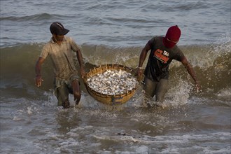 Sri Lankan fishermen with a basket of freshly caught fish