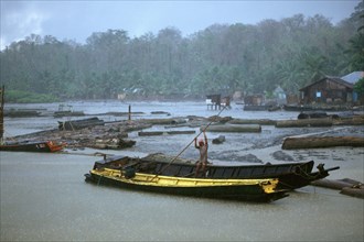 A boatmen tries to remove his boat as the rain pours