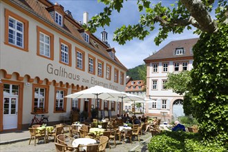 Gasthaus zum Eisernen Kreuz with guests on outdoor seating with plane trees