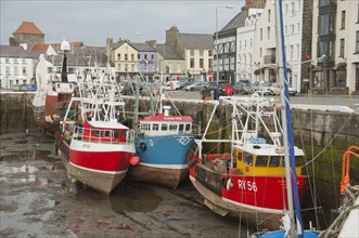 Fishing boats moored in the harbour of a coastal town