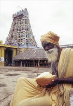 Sadhu holding conch standing infornt of Nataraja temple in Perur near Coimbatore