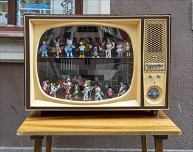 Decoration of play figures in an old tube television set