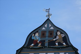 Gable of half-timbered house with wood carving and weather vane on market square