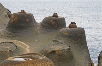 Candle-shaped rock formation on eroded coastal rock