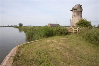 View of wind pump and pump house on the edge of the waterway