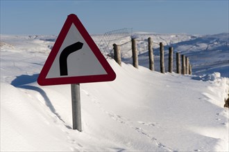 Road sign in snowdrift at roadside
