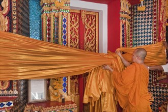 Monk attaches Songkran temple decoration