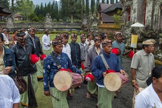 Balinese musicians carrying traditional instruments in procession