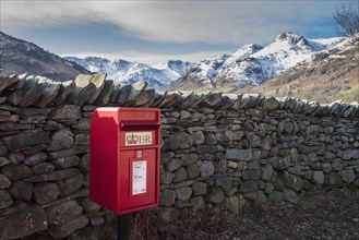 Royal Mail letterbox beside a dry stone wall