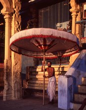 Temple Priest holding big Umbrella in Varadharaja Perumal temple in Kancheepuram