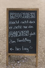 Board with a saying in front of a cafe