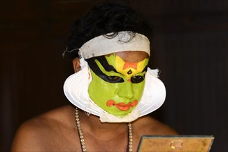 Kathakali dancer putting on make-up