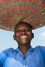 Smiling Rwandan girl with basket on her head