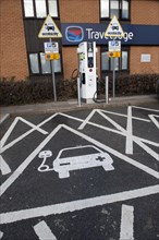 Reserved parking space at electric car charging point at motorway service station