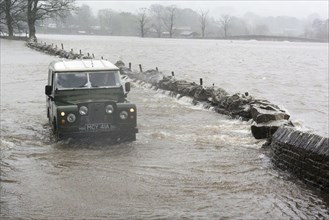 Vintage Land Rover on flooded road from Hawes to Simonstone Hall during Storm Desmond