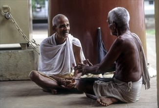 Two old man joyfully chit chatting in the temple