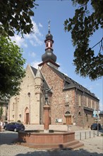 Romanesque St. James Church with onion tower and market fountain in Rheingau