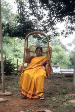 Mother sitting in hanging cane chair at Singara