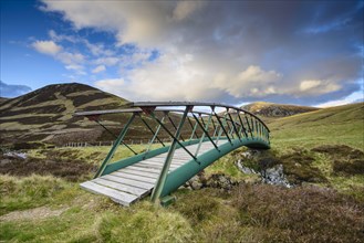 Metal footbridge over the river in Glen