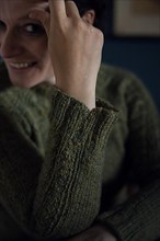 Interior shot of a woman in a knitted wool jumper