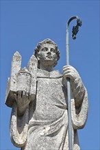 Saint St. Castor with bishop's crook and carrying miniature of collegiate church and Moselle cathedral in hand at Lindenplatz in Karden