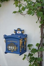 Historic blue post box with vines at the Lindenplatz in Karden