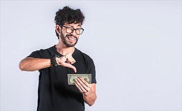 Unhappy man with a dollar bill with his thumb down
