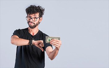 Sad person holding a banknote with his thumb down