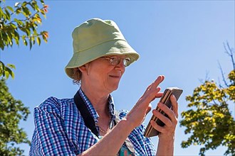 Elderly woman typing on smartphone