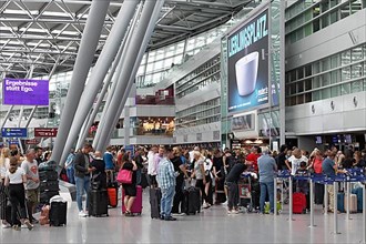 Passengers waiting for check-in in front of the check-in counter