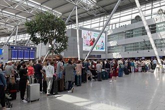 Passengers waiting for check-in in front of the check-in counter