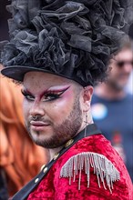 Made-up transvestite with hat and nose piercing takes part in CSD parade