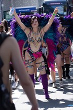 Scantily clad woman with colourful wings walk in the CSD parade