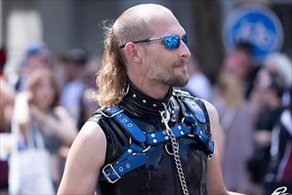 Leashed homosexual man from the SM scene in martial leather clothing at the CSD parade