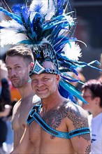 Homosexual man with naked torso and blue feather hat at the CSD parade