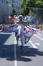 Transvestite costumed as a butterfly on stilts at the CSD parade