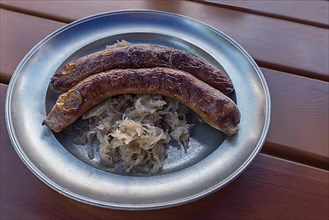 Pewter plate with two Franconian sausages and sauerkraut