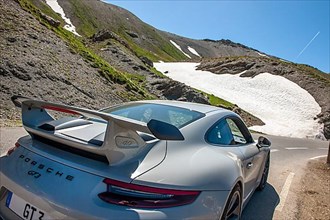 View on rear spoiler of supercar sports car Porsche GT3 on 2802 meters highest asphalted road in Alps
